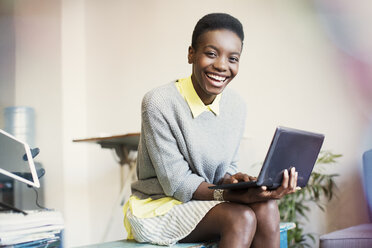 Portrait smiling businesswoman working with digital tablet - CAIF13558