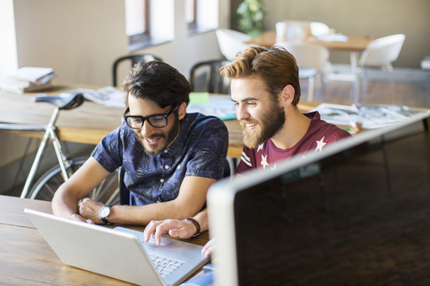 Casual businessmen working at laptop in office stock photo