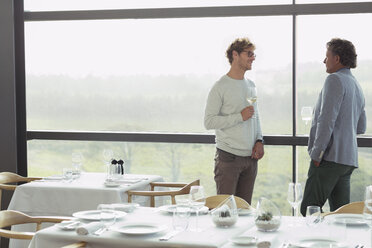 Männer trinken Wein am Fenster eines Restaurants - CAIF13670