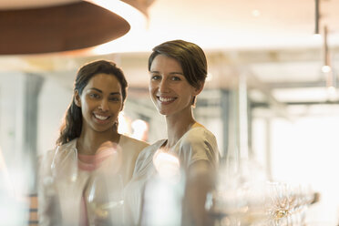 Porträt lächelnde Frauen bei einer Weinprobe im Verkostungsraum einer Weinkellerei - CAIF13705