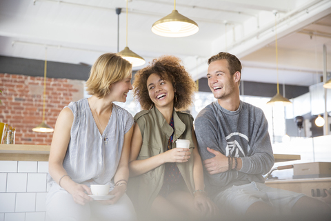 Lachende Freunde beim Kaffeetrinken im Café, lizenzfreies Stockfoto