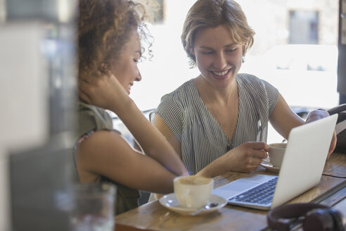 Geschäftsfrauen mit Kaffee, die in einem Café am Laptop arbeiten - CAIF13742