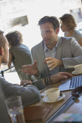 Businessmen talking and gesturing at cafe - CAIF13744