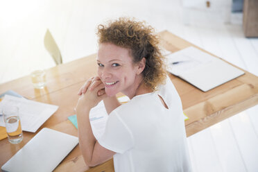 Portrait of young smiling office worker at desk - CAIF13790