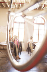 Kreative Geschäftsleute bei der Arbeit hinter dem Fahrrad im Büro - CAIF13917