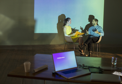 Geschäftsleute bei der Vorbereitung einer audiovisuellen Präsentation im Konferenzraum, lizenzfreies Stockfoto