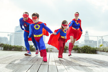 Superhero family playing on city rooftop - CAIF13961