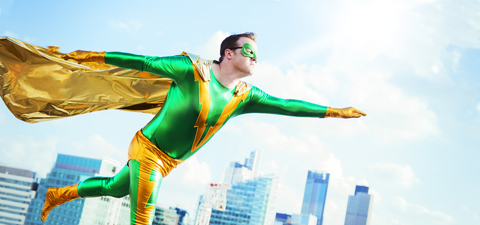Superheld fliegt auf dem Dach der Stadt, lizenzfreies Stockfoto