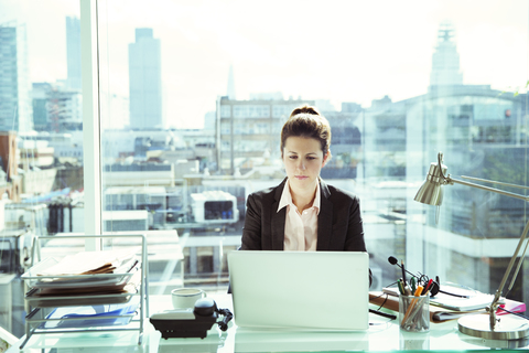 Geschäftsfrau arbeitet am Laptop im Büro, lizenzfreies Stockfoto