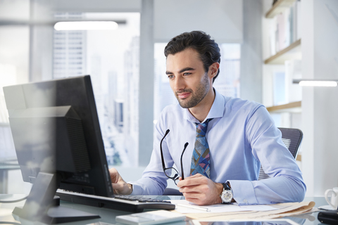 Portrait of man sitting at his desk in office stock photo