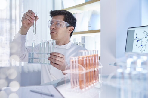 Mann arbeitet im Labor und hält ein Gefäß - CAIF14023