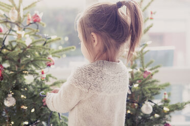 Mädchen schmückt Weihnachtsbaum - CAIF14058