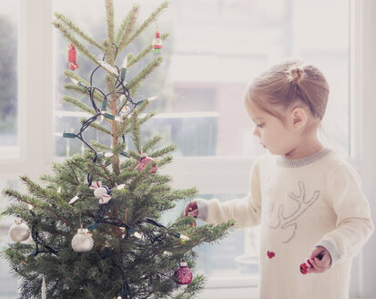 Mädchen schmückt kleinen Weihnachtsbaum - CAIF14061