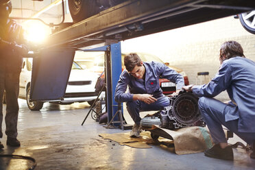 Mechaniker bei der Prüfung eines Teils in der Autowerkstatt - CAIF14069