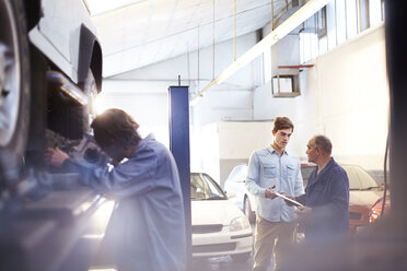 Mechanic speaking with customer in auto repair shop - CAIF14070