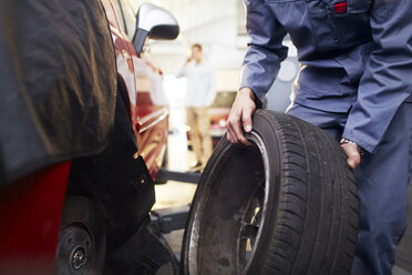 Mechanic replacing tire in auto repair shop - CAIF14080