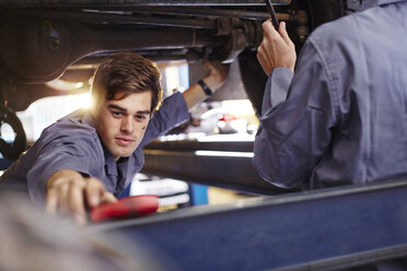 Mechanic reaching for tool in auto repair shop - CAIF14085