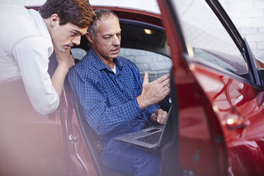 Mechaniker mit Laptop am Auto in der Autowerkstatt - CAIF14087