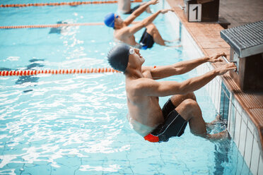 Schwimmerinnen und Schwimmer stehen am Startblock im Schwimmbecken bereit - CAIF14126