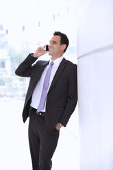 Smiling businessman talking on cell phone - CAIF14225