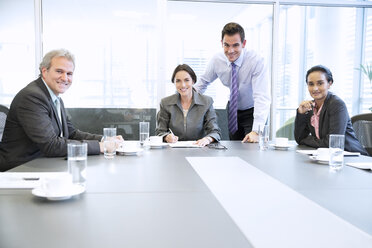 Porträt von lächelnden Geschäftsleuten, die sich in einem Konferenzraum treffen - CAIF14247