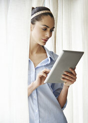 Frau benutzt digitales Tablet am Fenster - CAIF14263