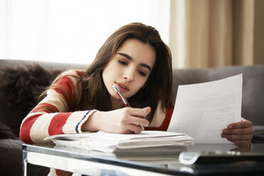 Girl doing homework at coffee table - CAIF14267