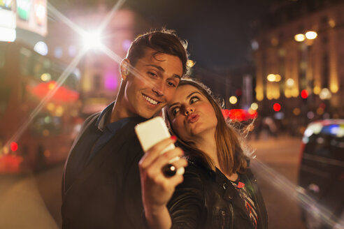 Paar fotografiert zusammen mit Handy bei Nacht - CAIF14268