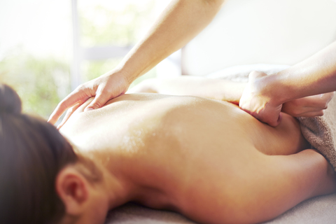Masseuse massaging woman’s back stock photo