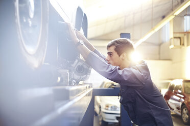 Mechaniker arbeitet an einem Auto in einer Autowerkstatt - CAIF14432