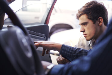 Mechaniker und Kunde mit Laptop im Auto - CAIF14438