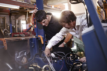 Mechaniker arbeiten an einem Auto in einer Autowerkstatt - CAIF14445