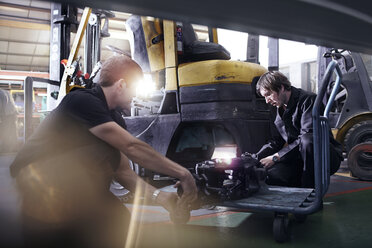 Mechanics fixing forklift in auto repair shop - CAIF14456