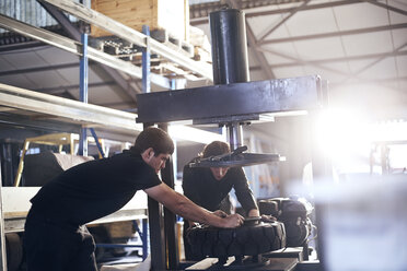 Mechanics fixing tire in auto repair shop - CAIF14458