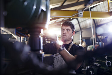 Fokussierter Mechaniker, der in einer Autowerkstatt arbeitet - CAIF14461