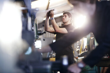 Mechanic examining part in auto repair shop - CAIF14467