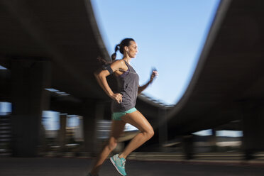 Woman running through city streets - CAIF14510