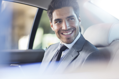 Lächelnder Geschäftsmann im Auto sitzend, lizenzfreies Stockfoto