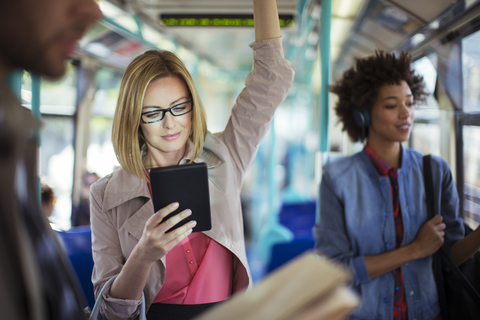 Businesswoman using digital tablet on train stock photo