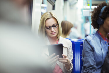 Businesswoman using digital tablet on train - CAIF14561