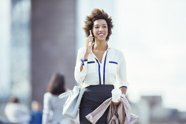 Businesswoman talking on cell phone in city - CAIF14574