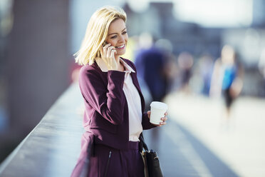 Businesswoman talking on cell phone on urban bridge - CAIF14593