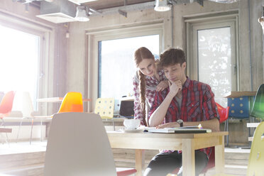 Creative business people reading in sunny office - CAIF14626