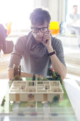 Fokussierter Architekt betrachtet Modell im Büro - CAIF14649