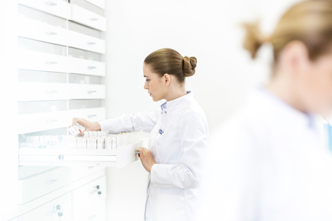 Apothekerin füllt Rezept in der Apotheke aus, lizenzfreies Stockfoto