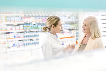 Pharmacist and customer talking in pharmacy - CAIF14675