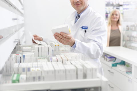 Pharmacist filling prescription in pharmacy stock photo