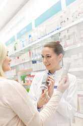 Pharmacist recommending product to customer in pharmacy - CAIF14690