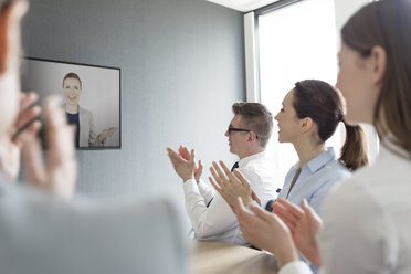 Business people clapping for businesswoman on video conference screen - CAIF14757