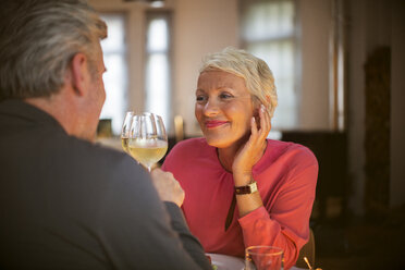 Older couple toasting each other with white wine - CAIF14802